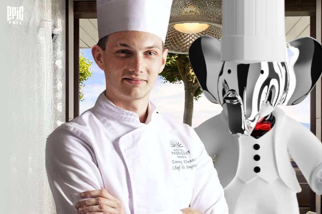 Le chef Danny Khezzar en tenue blanche de cuisine, aux côtés d’une statue chromée d’éléphant Babolex en uniforme de chef, dans un cadre luxueux marqué par le logo Epic Fail.